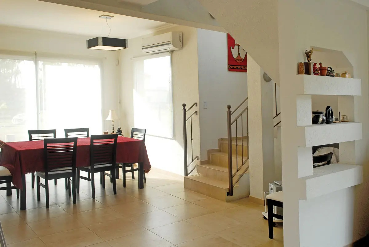 Comedor moderno con mesa grande y sillas oscuras, luz natural abundante — proyecto Casa El Recodo, por Fhee Construcciones, en Garin