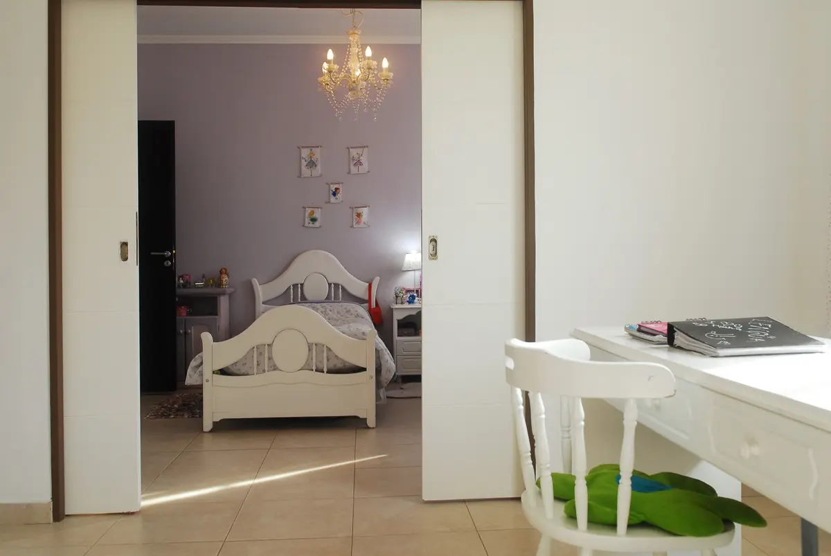 Dormitorio clásico con área de estudio y cama ornamentada — proyecto Casa El Recodo, por Fhee Construcciones, en Garin