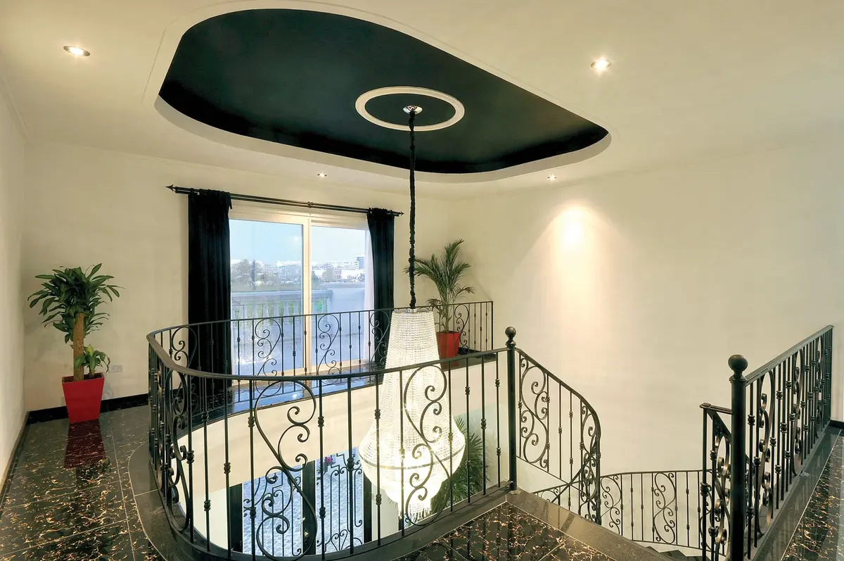 Corredor e escada modernos com teto curvo preto e iluminação embutida — projeto Casa 4, por Fhee Construcciones, em Nordelta