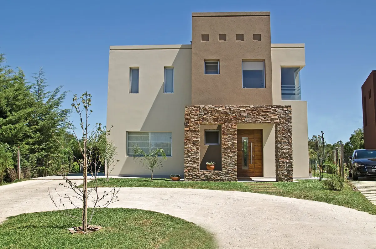 Casa moderna com fachada de pedra e concreto — projeto Casa 3, por Fhee Construcciones, em Rincón de La Costa