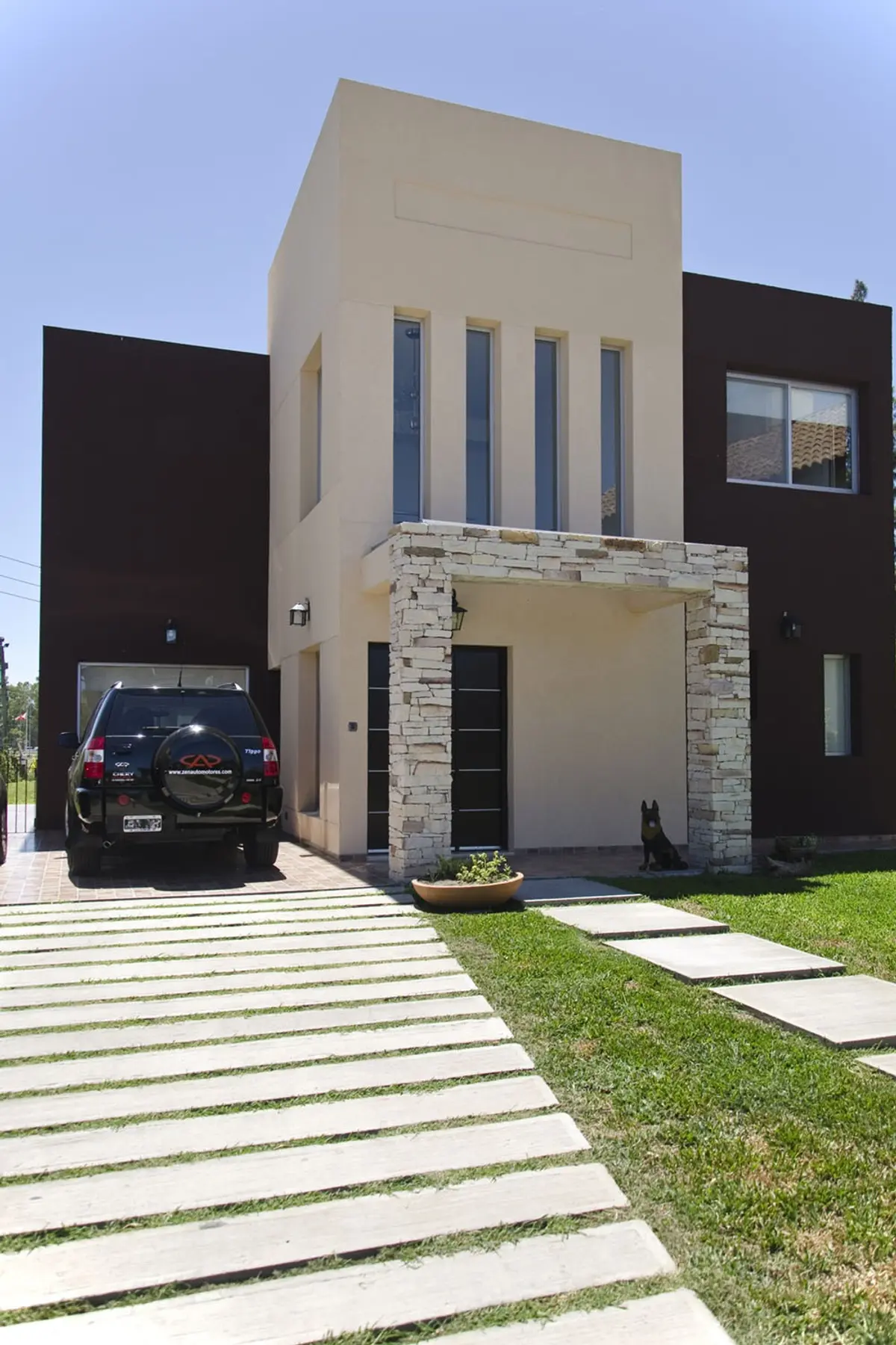 casa moderna com fachadas contrastantes e SUV preto — projeto Casa 2, por Fhee Construcciones, em Rincón de La Costa