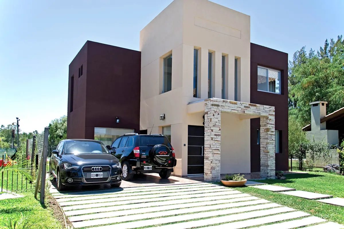 Casa moderna com fachada geométrica e carros — projeto Casa 2, por Fhee Construcciones, em Rincón de La Costa
