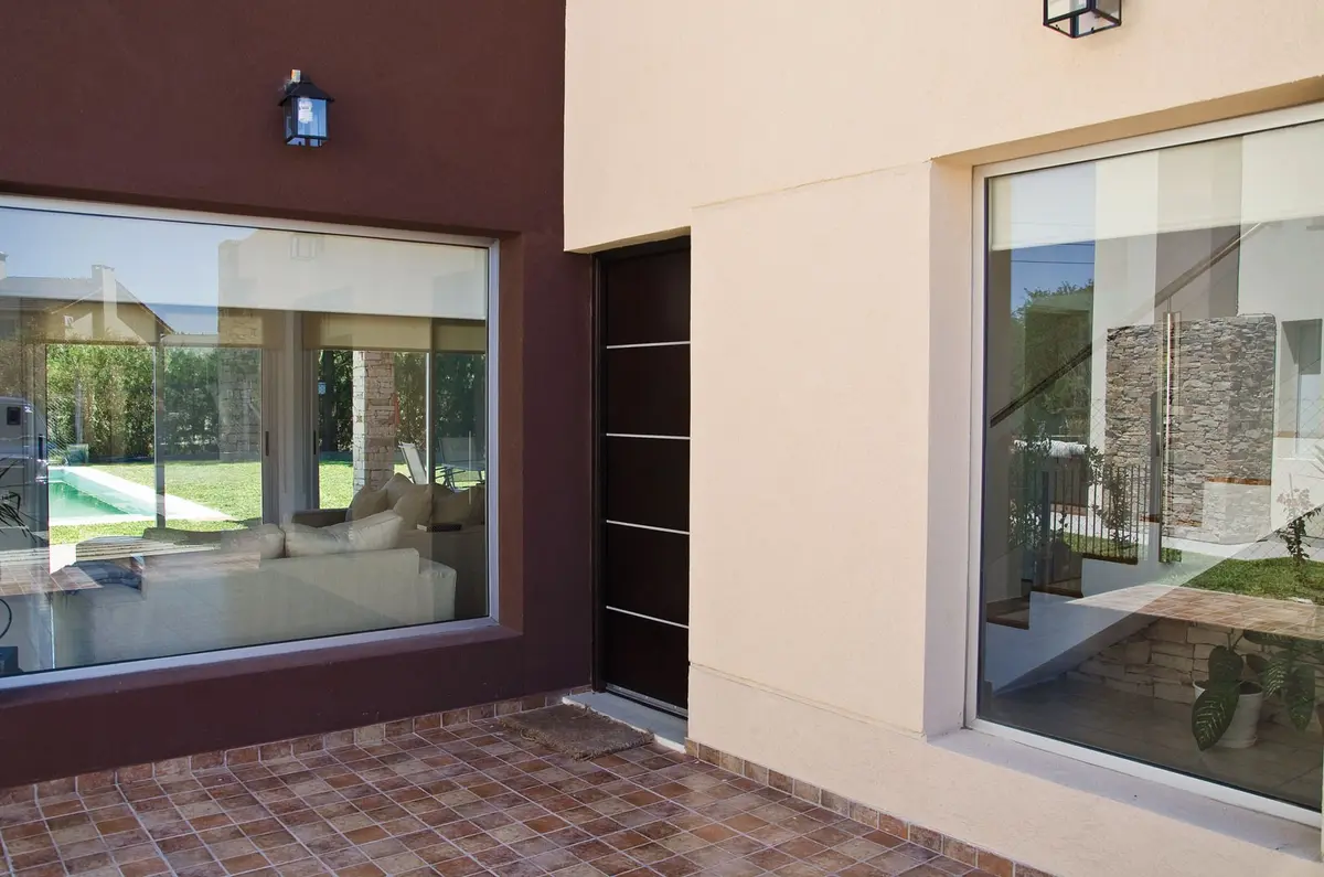 Pátio moderno com piso de terracota e grandes janelas — projeto Casa 2, por Fhee Construcciones, em Rincón de La Costa