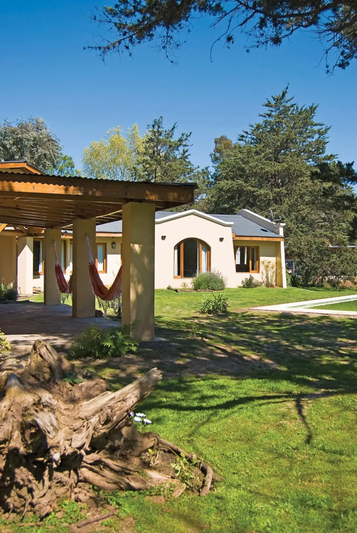 Fachada de chalé rural com pergolado de madeira e redes — projeto Casa 1, por Fhee Construcciones, em El Cazador