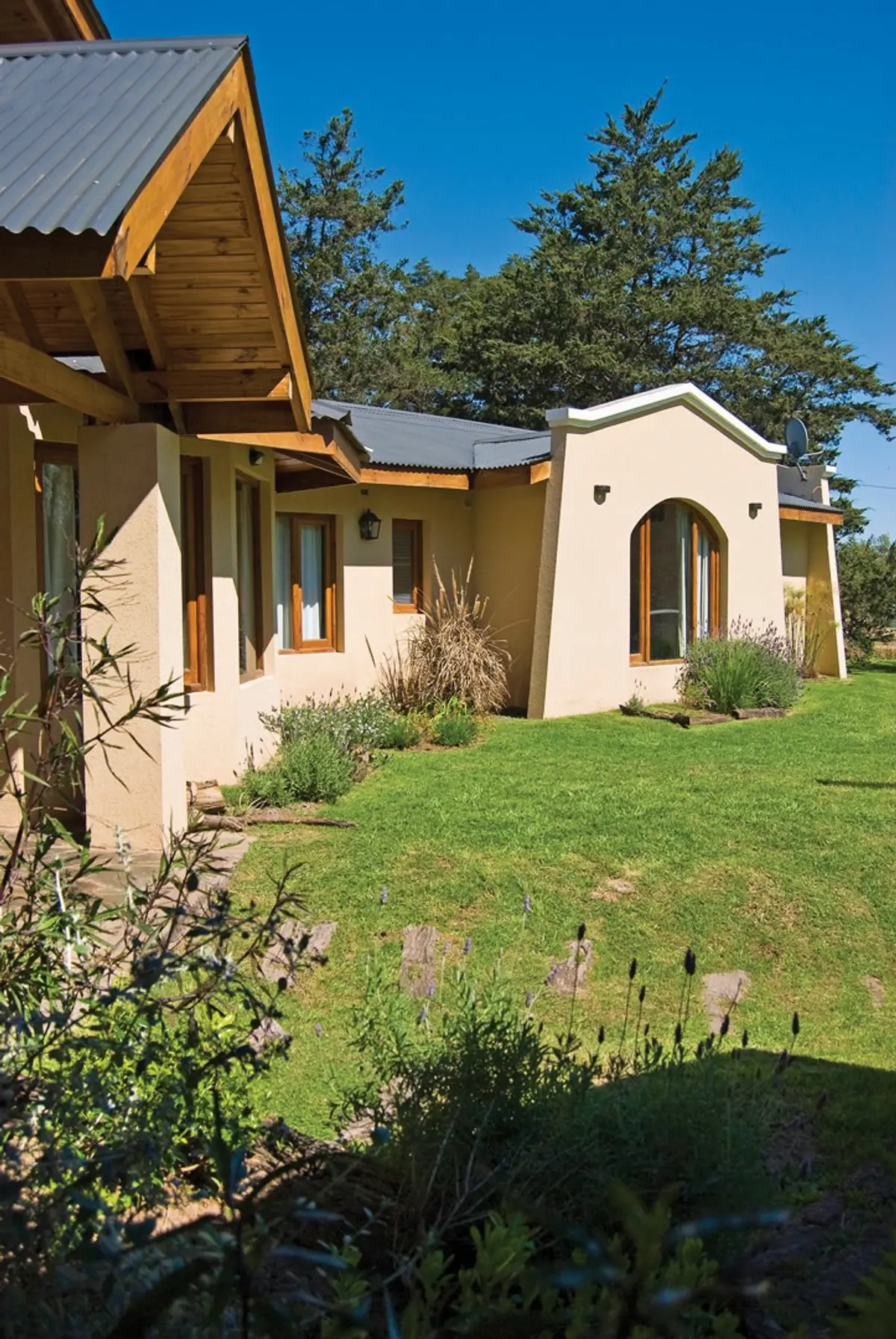 fachada de casa rural com arcos e telhado de chapa — projeto Casa 1, por Fhee Construcciones, em El Cazador