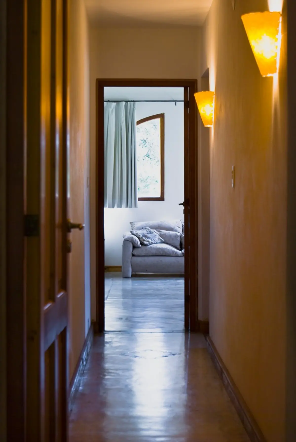 Corredor com luzes quentes e vista para sala com sofá — projeto Casa 1, por Fhee Construcciones, em El Cazador