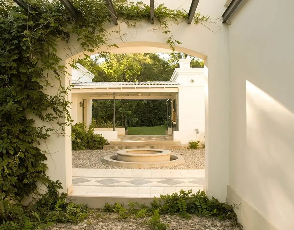Patio mediterráneo con fuente central y vegetación exuberante — proyecto Alta Gracia, por Ricardo Pereyra Iraola , en Alta Gracia