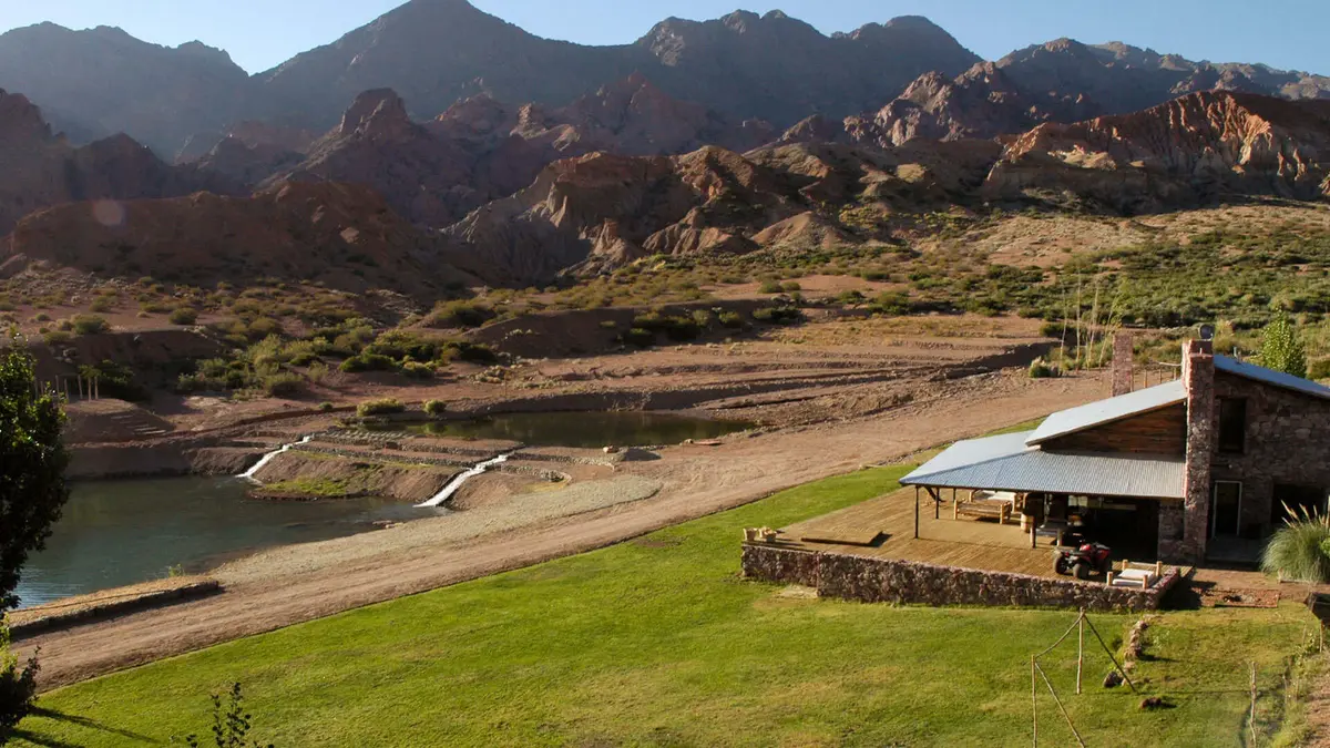 casa rústica de pedra e madeira na montanha com pátio — projeto Cerro de Uspallata, por Ricardo Pereyra Iraola, em Uspallata