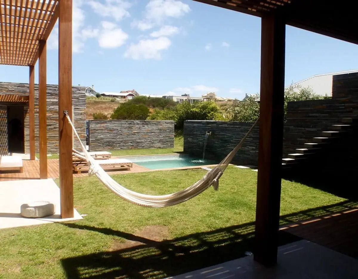hamaca blanca en patio rural con muros de piedra — proyecto Costa Uruguaya, por Ricardo Pereyra Iraola 