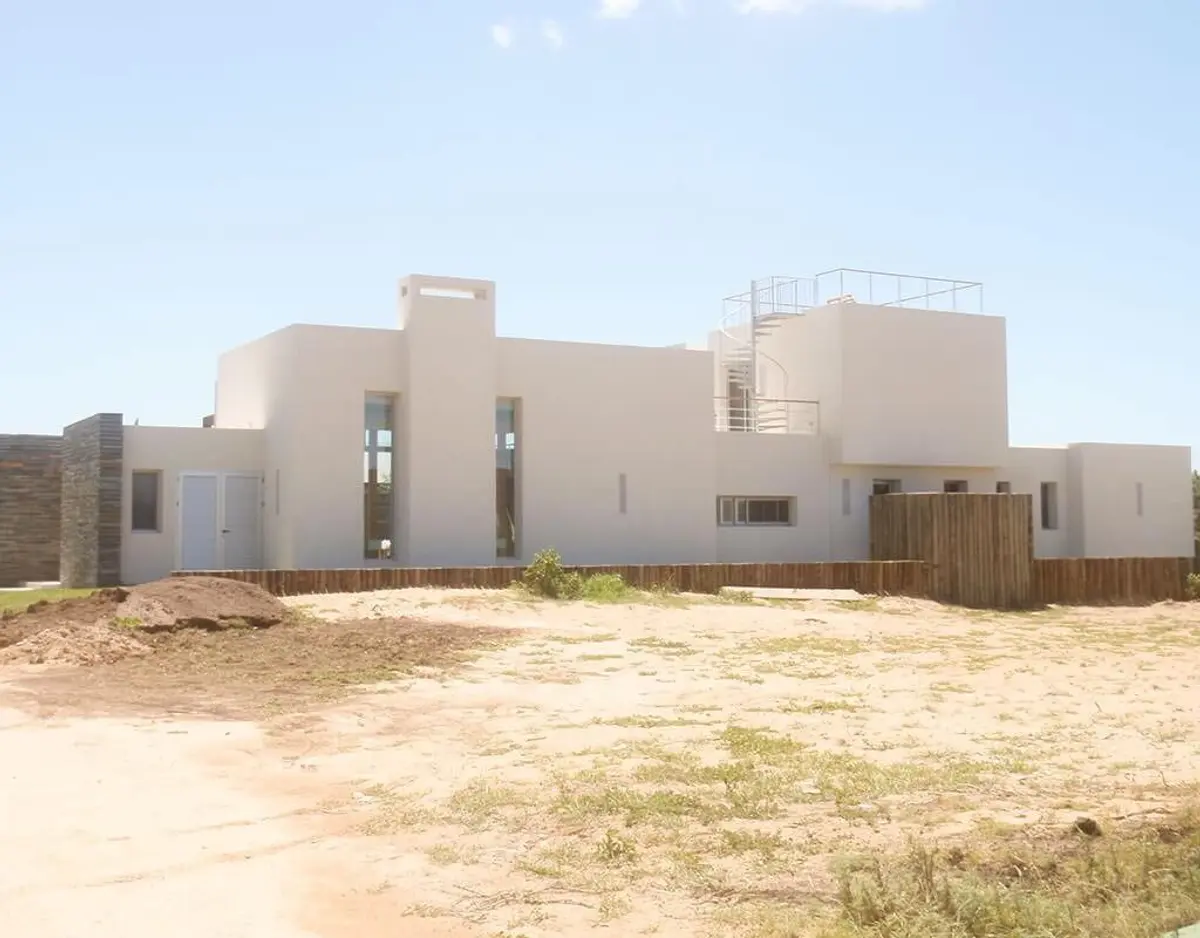 Casa moderna blanca en construcción, con detalles en madera — proyecto Costa Uruguaya, por Ricardo Pereyra Iraola 