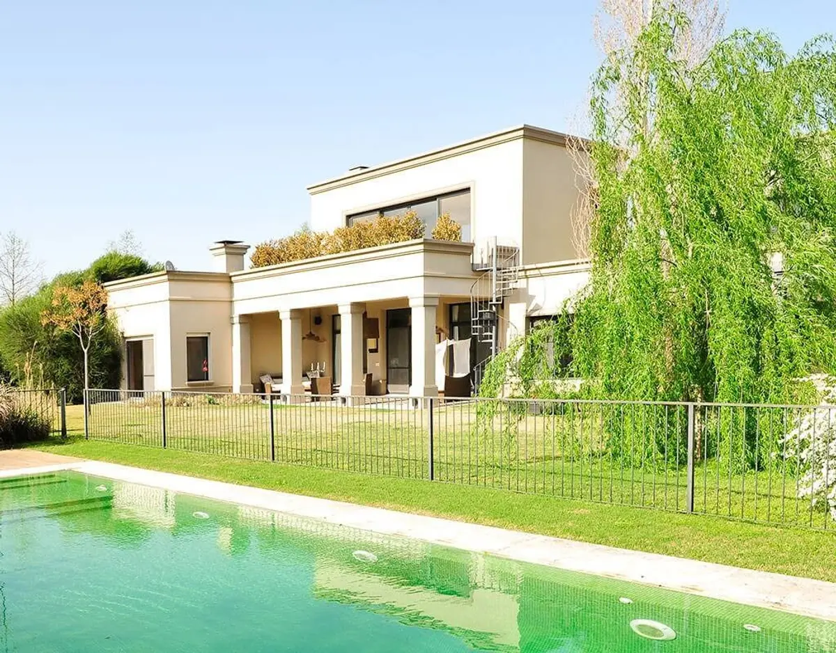 Fachada moderna branca com piscina e jardim exuberante — projeto Elegante Equilibrio, por Ricardo Pereyra Iraola