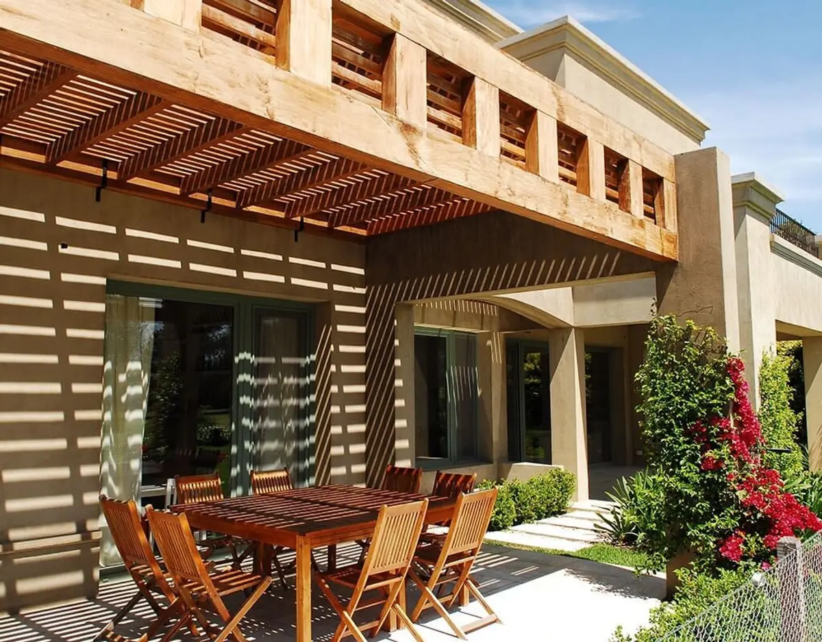 Pérgola de madeira e pátio externo moderno com móveis de madeira — projeto Fondo al Golf, por Ricardo Pereyra Iraola