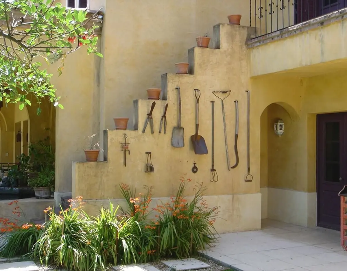 fachada mediterrânea com ferramentas de jardim e plantas — projeto Gitana, por Ricardo Pereyra Iraola