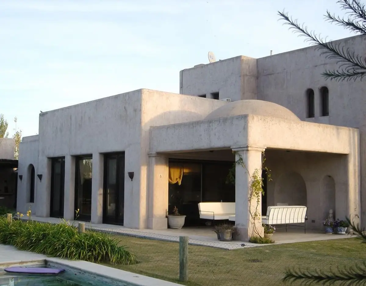 Fachada de casa mediterrânea com arcos e pátio externo — projeto La Intriga, por Ricardo Pereyra Iraola