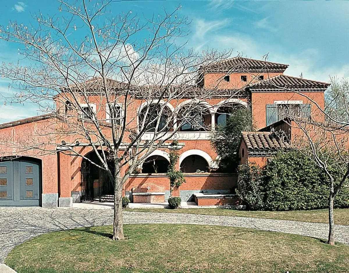 Fachada de casa mediterránea con ladrillos terracota y arcos — proyecto Las Arcadas, por Ricardo Pereyra Iraola 
