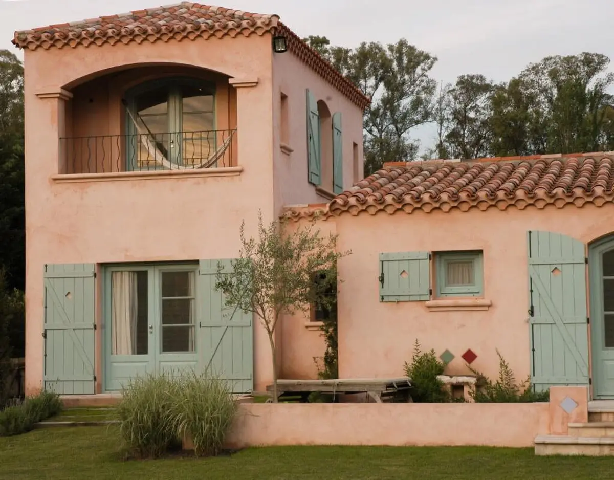 fachada mediterránea con tejas de terracota y postigos azules — proyecto Les Confines, por Ricardo Pereyra Iraola 
