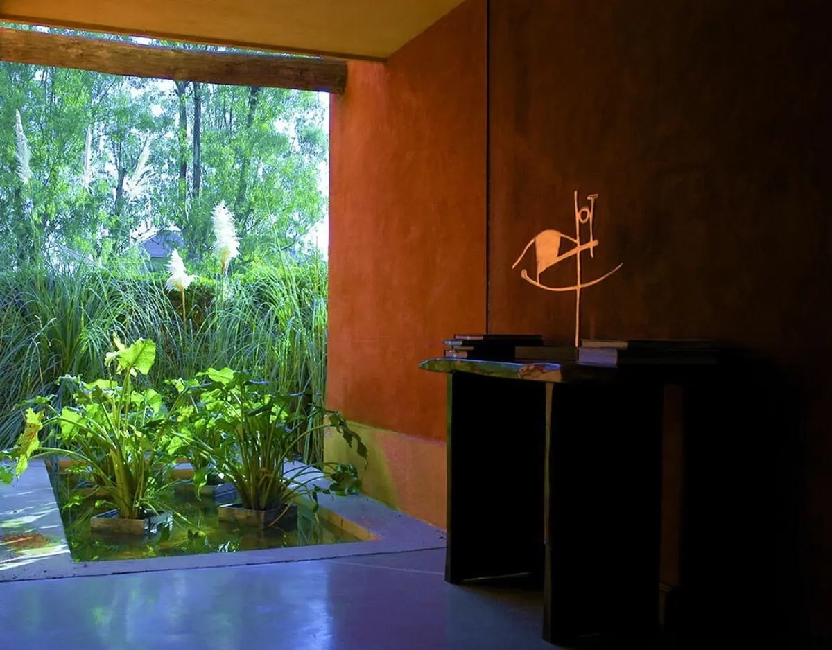 Patio moderno con pared terracota y vista al bosque frondoso — proyecto Paisajismo Agua, por Ricardo Pereyra Iraola 