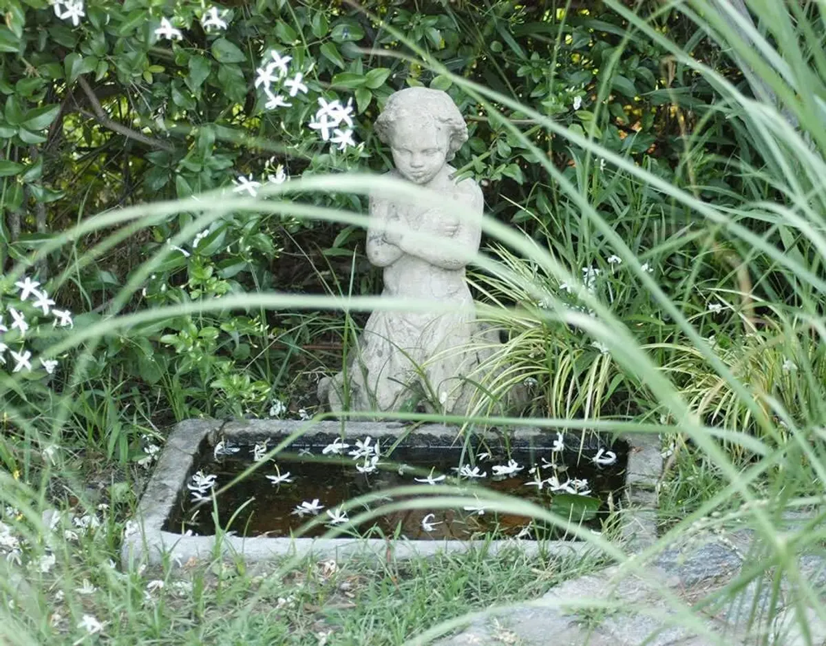 jardim com estátua e fonte de pedra — projeto Paisajismo Agua, por Ricardo Pereyra Iraola