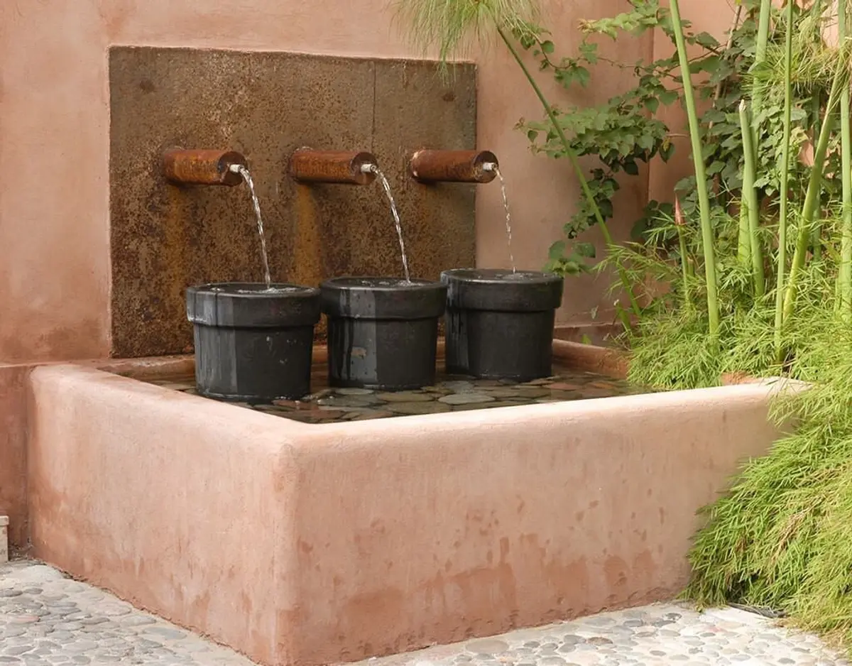 Fonte de três bicos em pátio com vegetação — projeto Paisajismo Agua, por Ricardo Pereyra Iraola