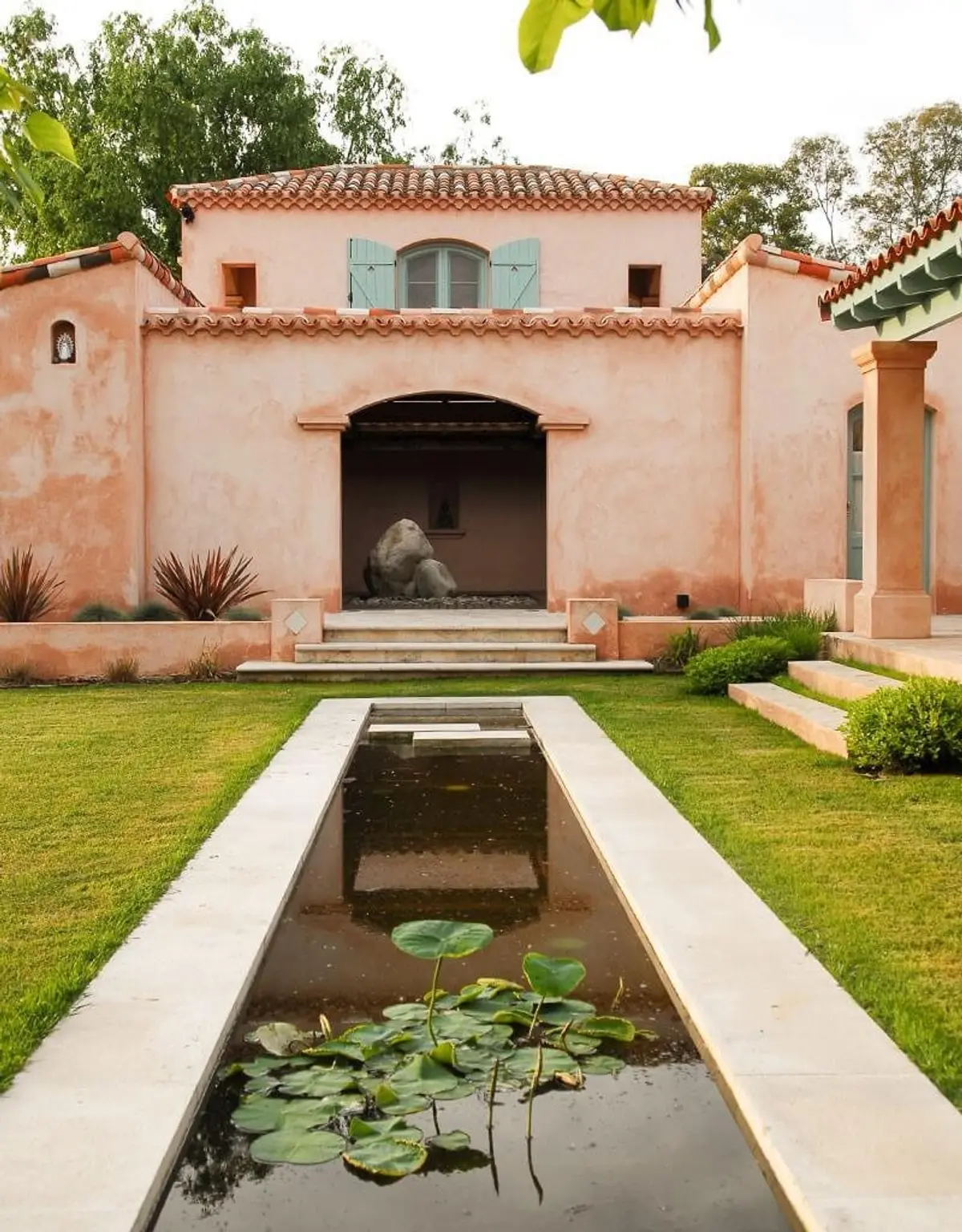 fachada mediterrânea com espelho d'água e escultura — projeto Paisajismo Agua, por Ricardo Pereyra Iraola