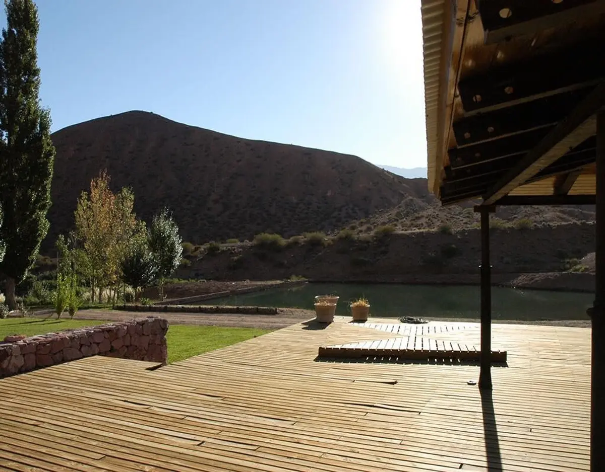 Deck de madeira rústico com vista para montanhas e lago — projeto Paisajismo Aire, por Ricardo Pereyra Iraola