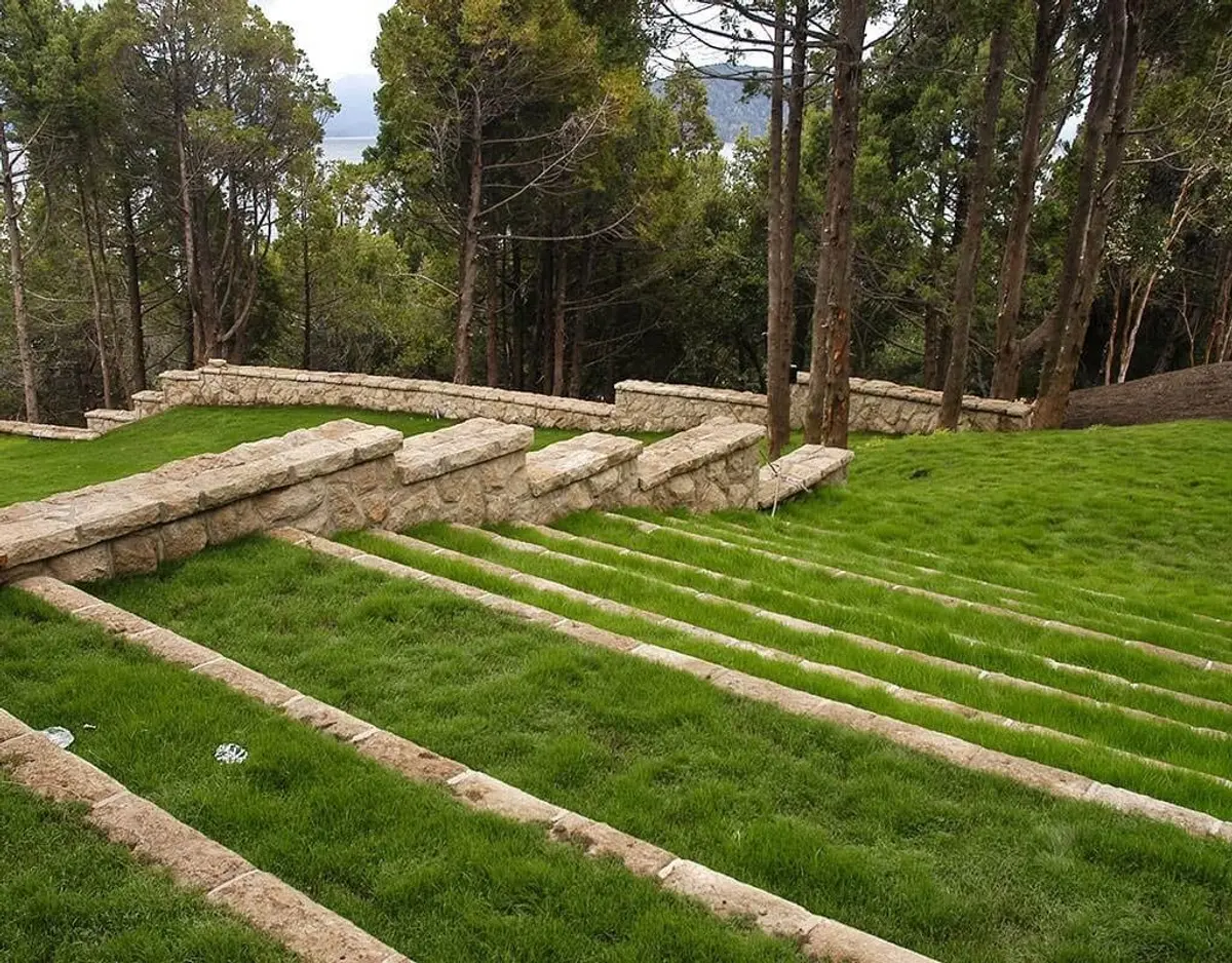 Terraço de grama com degraus de pedra em ambiente de floresta — projeto Paisajismo Aire, por Ricardo Pereyra Iraola
