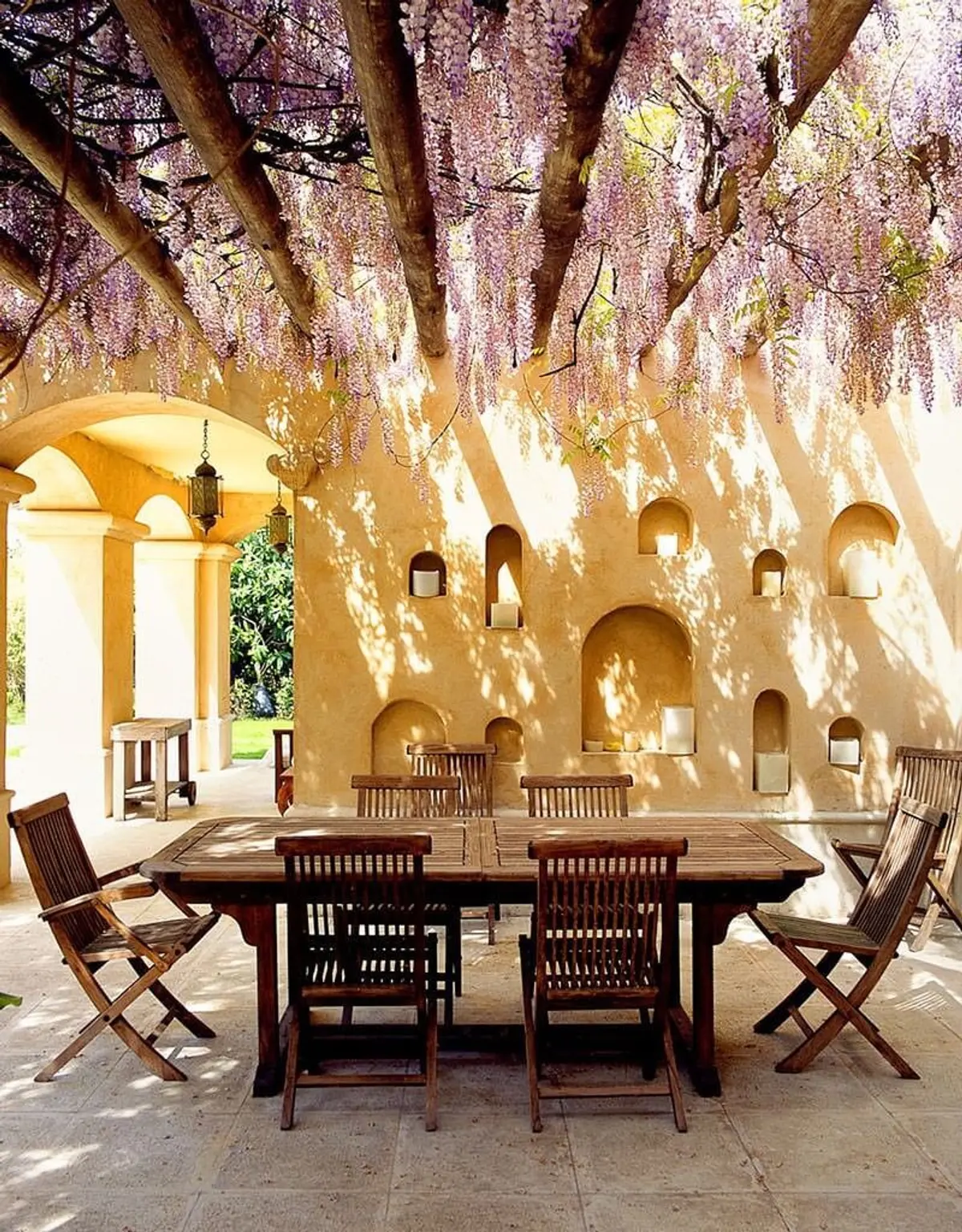 Patio rústico con glicinas y mesa de comedor de madera — proyecto Paisajismo Aire, por Ricardo Pereyra Iraola 