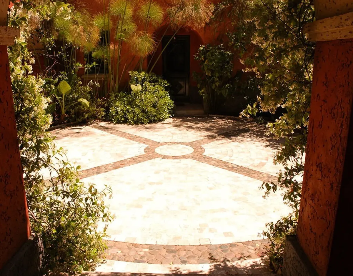 Patio de piedra con plantas exuberantes y paredes terracota — proyecto Paisajismo Tierra, por Ricardo Pereyra Iraola 