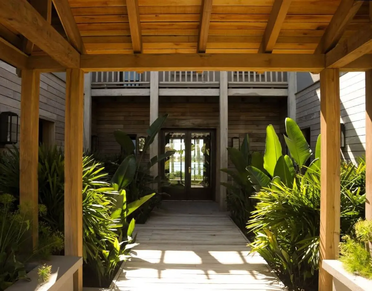 Sendero de madera con pérgola y vegetación exuberante — proyecto Terrazas a La Laguna, por Ricardo Pereyra Iraola 