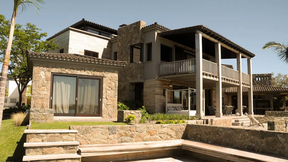 Fachada moderna mediterránea con piedra y deck — proyecto Terrazas a La Laguna, por Ricardo Pereyra Iraola 