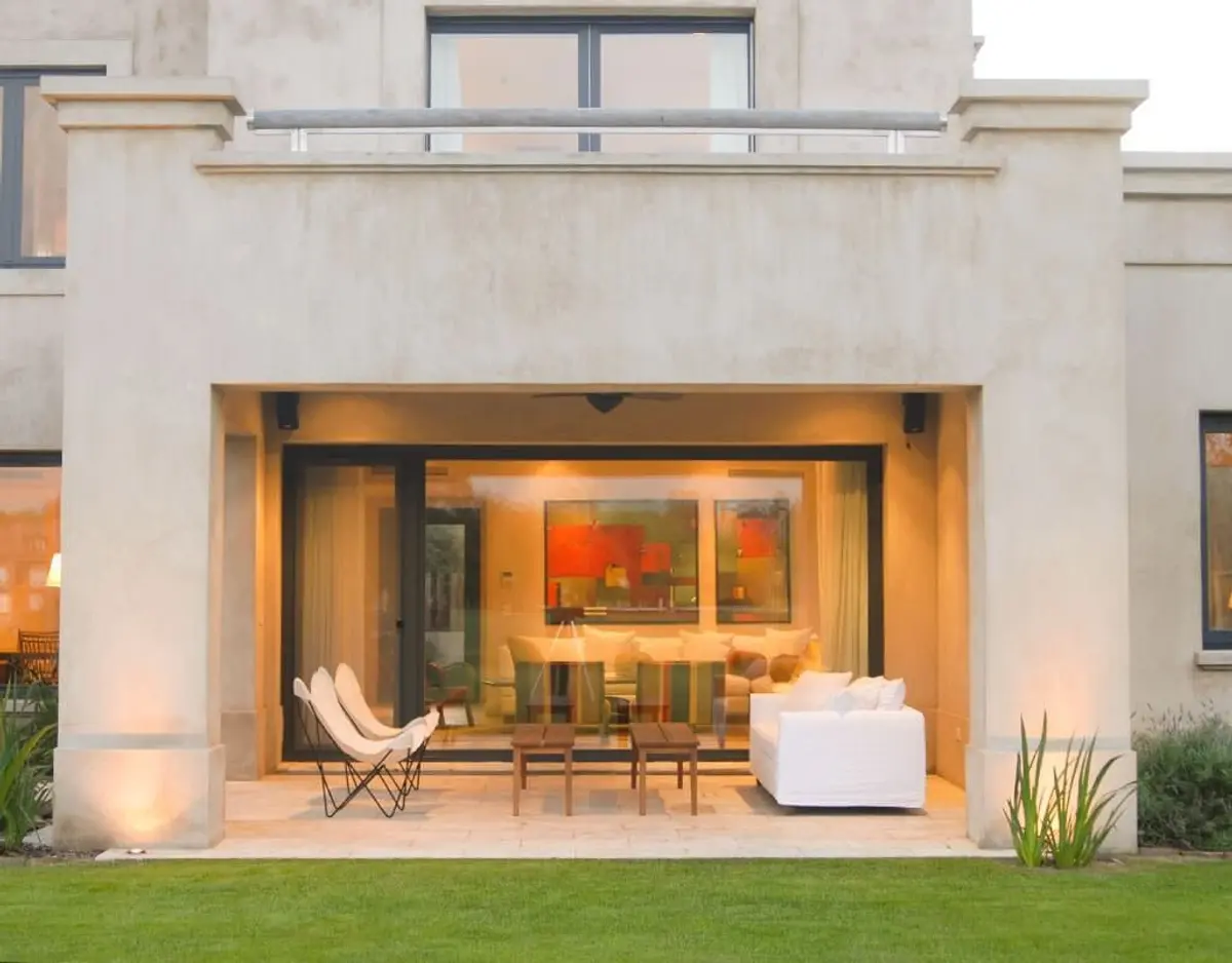 Fachada moderna con patio integrado y muebles blancos — proyecto Jardín Interior, por Ricardo Pereyra Iraola 