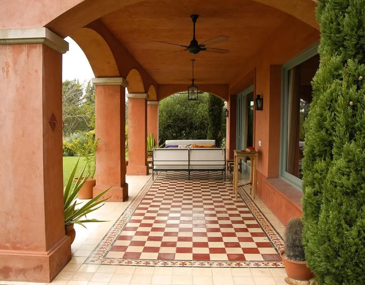 Pátio coberto mediterrâneo com piso quadriculado e sofá externo — projeto Vivencias Salteñas, por Ricardo Pereyra Iraola