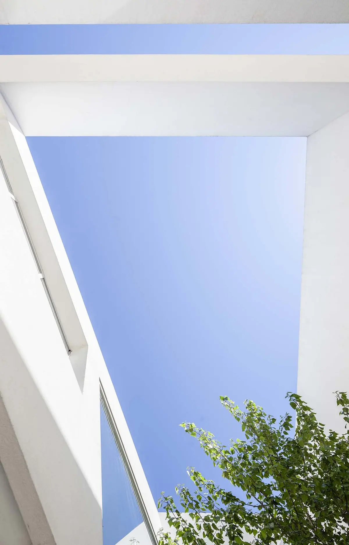 Fachada moderna de hormigón blanco con cielo azul y vegetación — proyecto Casa MA, por Estudio GR, en City Bell