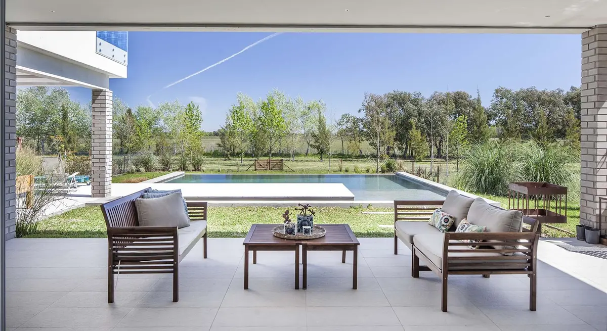 Pátio moderno coberto com piscina e vista para o campo — projeto Casa MA, por Estudio GR, em City Bell