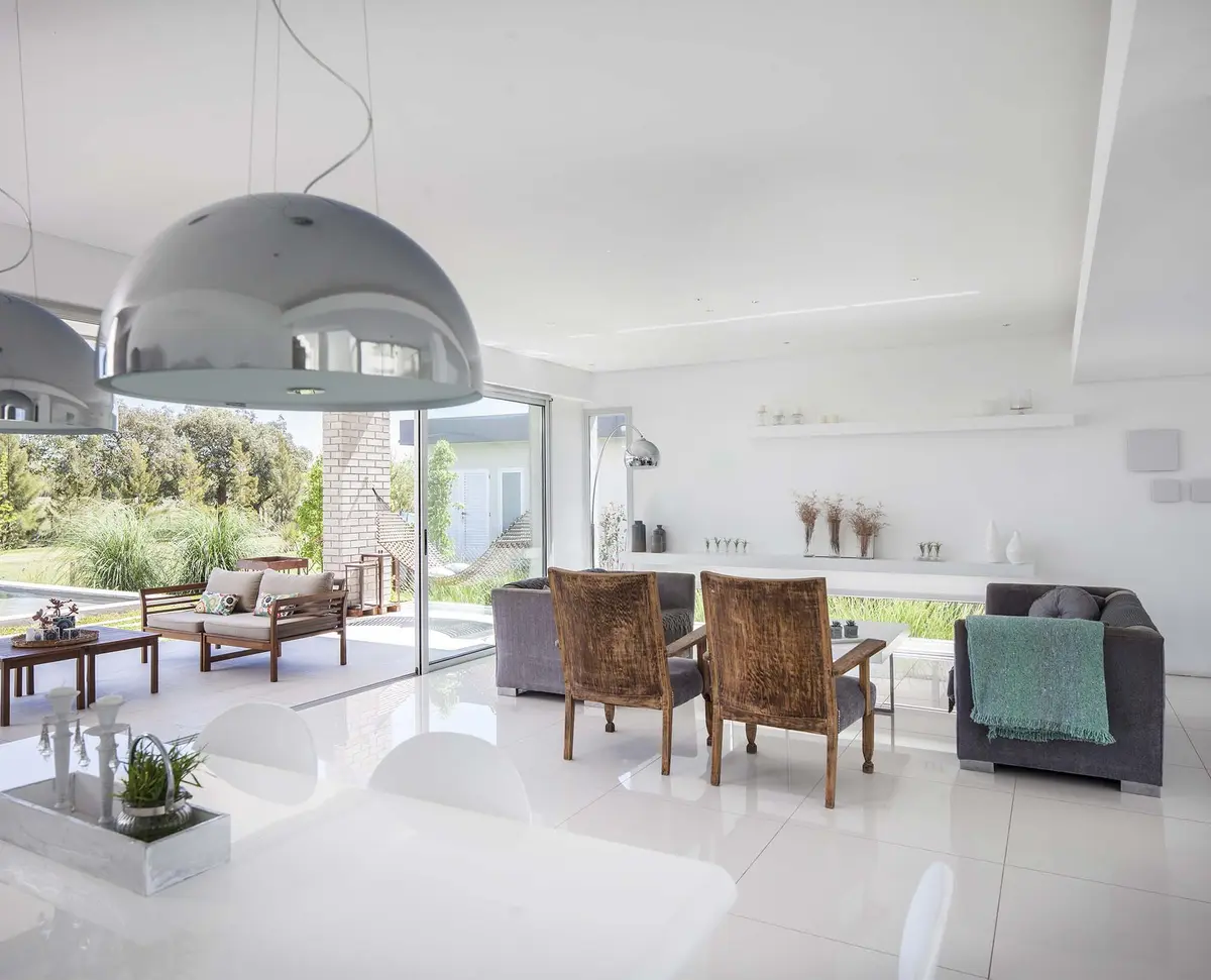 Living comedor moderno con vista al mar y lámpara colgante grande — proyecto Casa MA, por Estudio GR, en City Bell