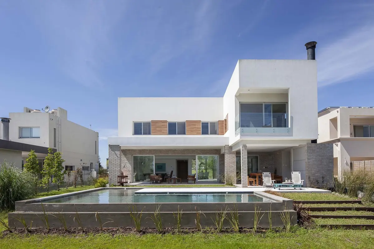 Casa moderna branca com piscina e pátio externo — projeto Casa MA, por Estudio GR, em City Bell