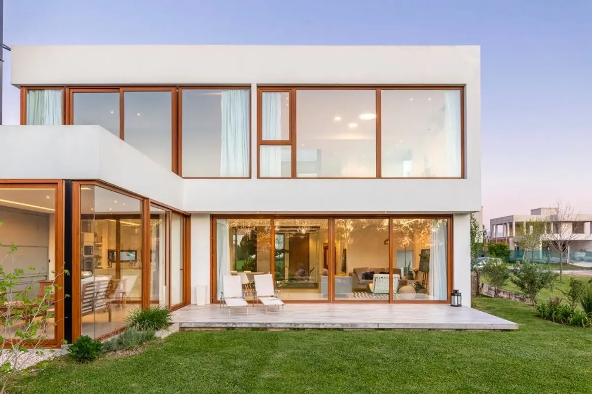 Fachada moderna con grandes ventanales y detalles en madera — proyecto Casa ME, por Estudio GR, en City Bell