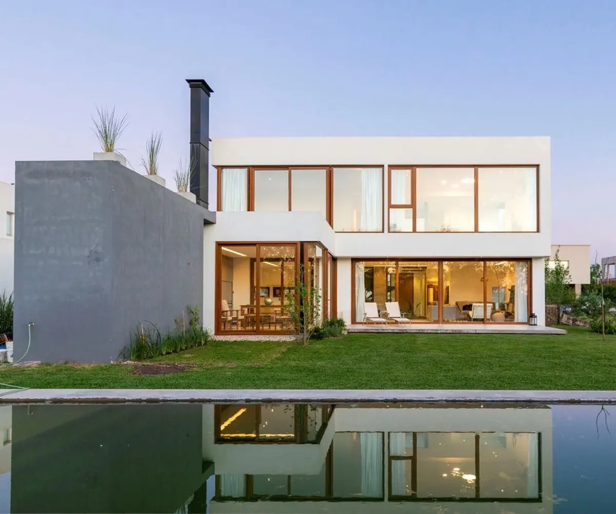Casa moderna com grandes janelas e volume de concreto — projeto Casa ME, por Estudio GR, em City Bell