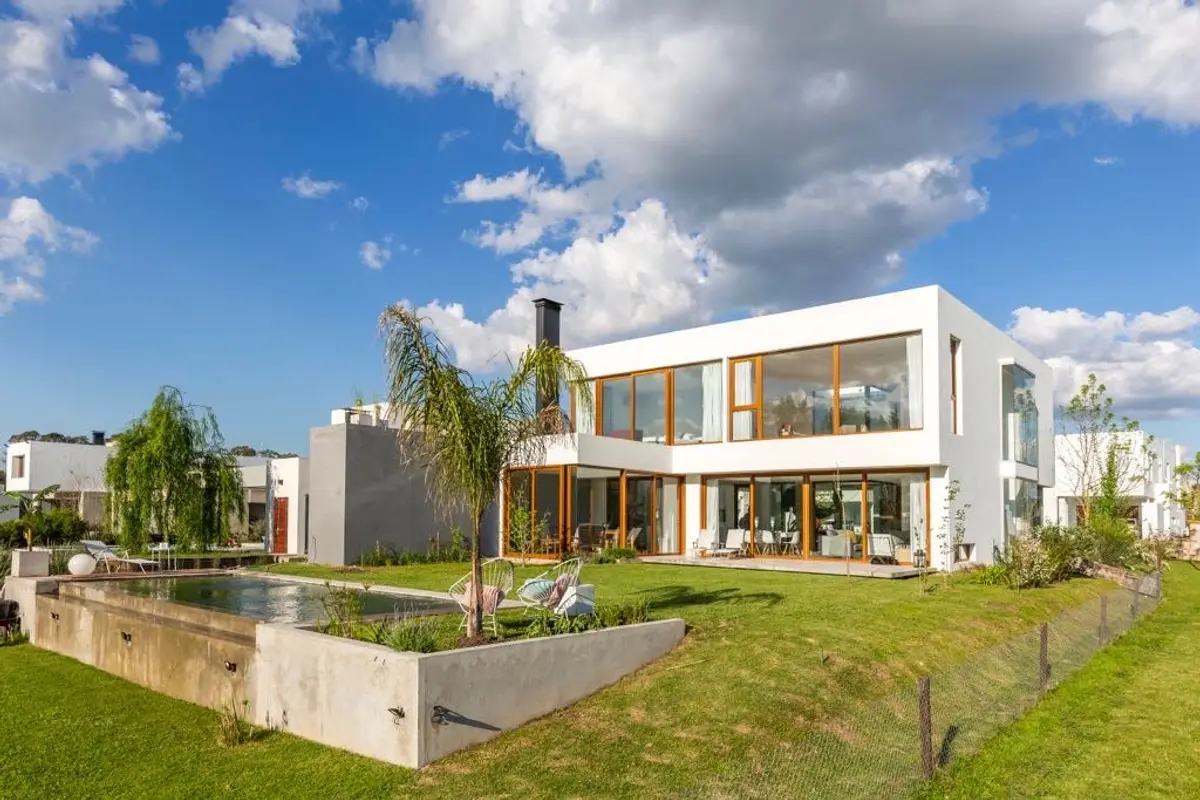 Casa moderna com piscina e janelas do chão ao teto em ambiente suburbano — projeto Casa ME, por Estudio GR, em City Bell