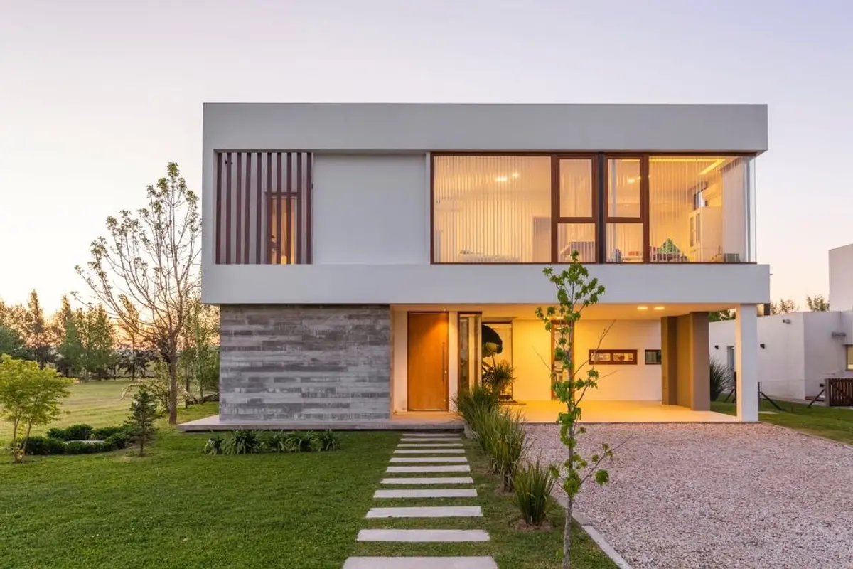 Casa moderna minimalista con grandes ventanales y jardín cuidado — proyecto Casa ME, por Estudio GR, en City Bell