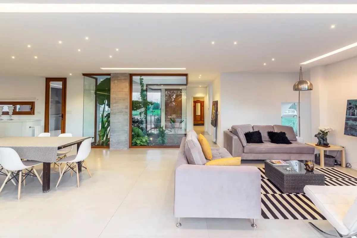 Living moderno con jardín interior y grandes ventanales — proyecto Casa ME, por Estudio GR, en City Bell