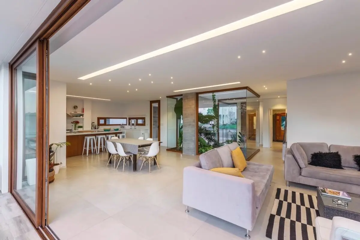 Living moderno con sofás grandes y ventanales amplios — proyecto Casa ME, por Estudio GR, en City Bell