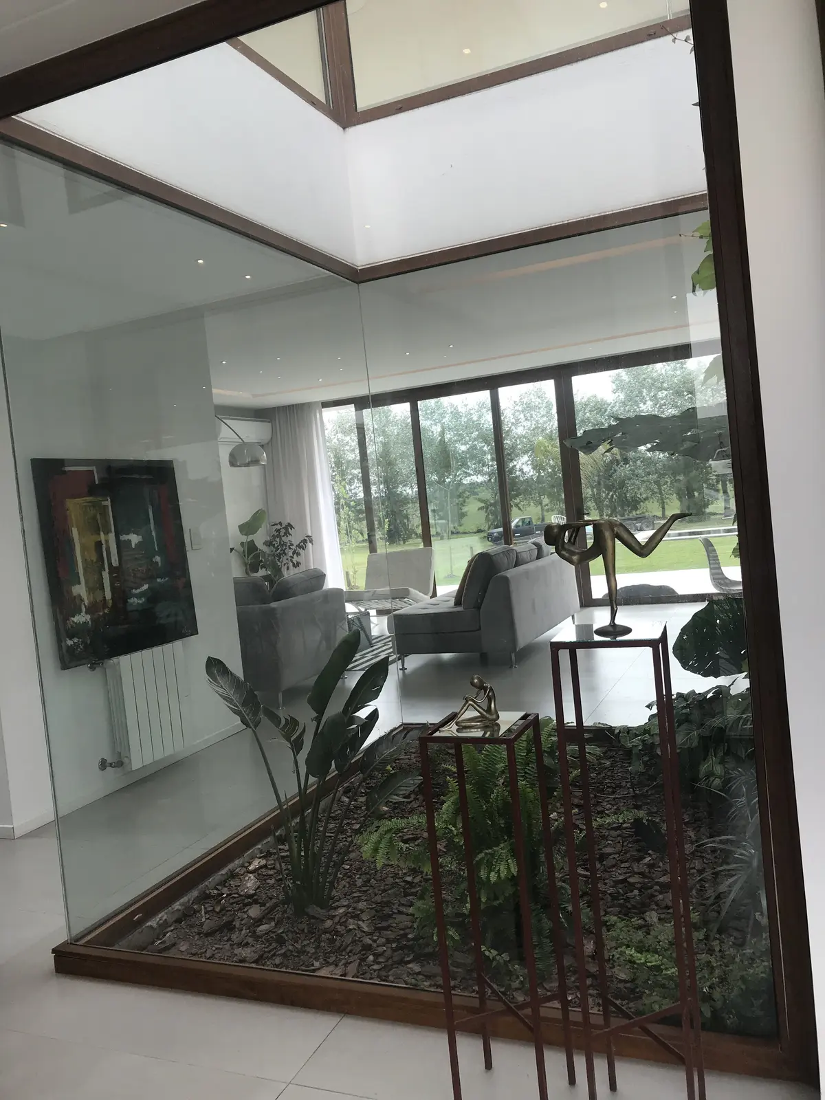 Living moderno con jardín interior y techos altos — proyecto Casa ME, por Estudio GR, en City Bell