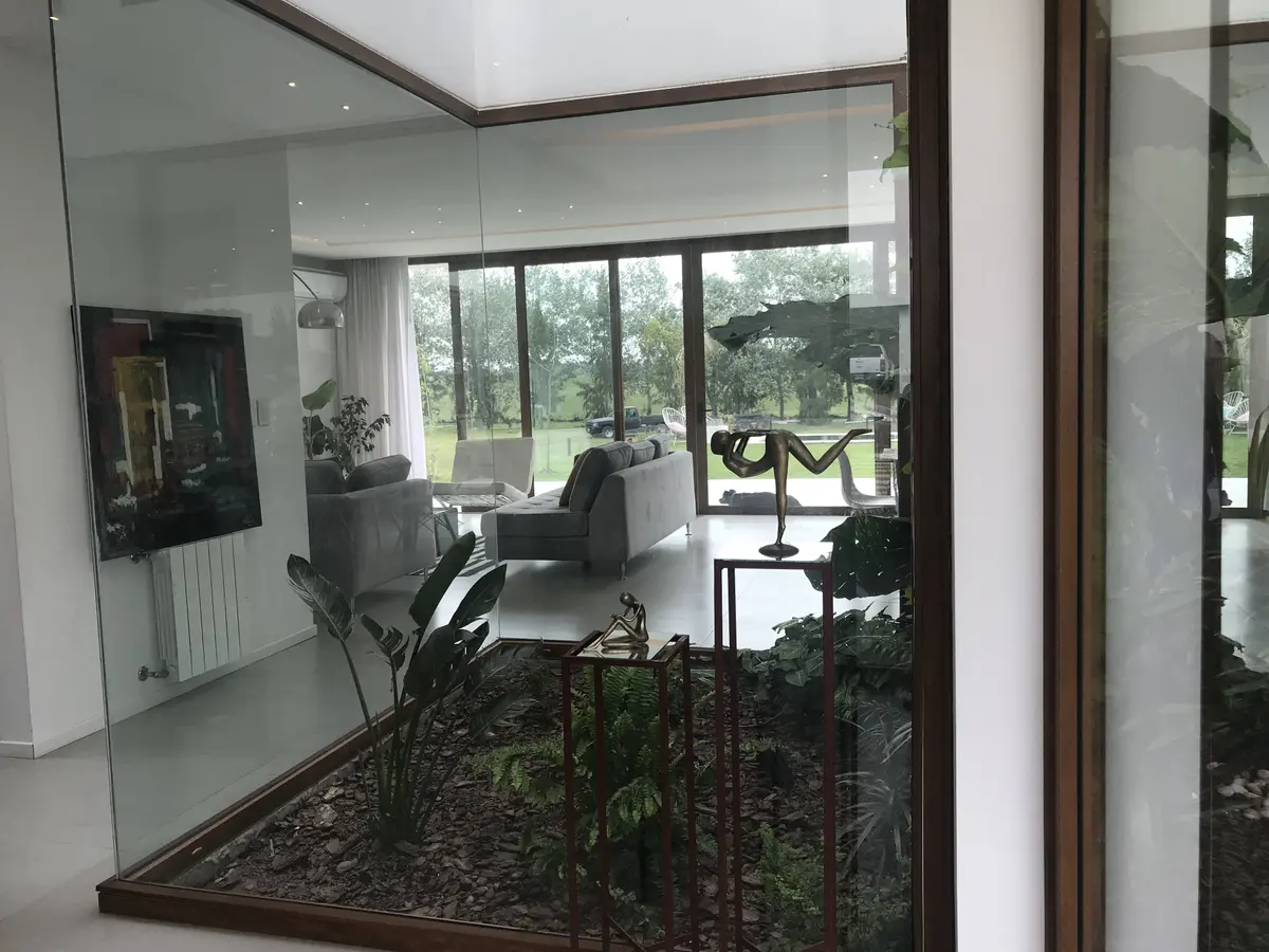 Living moderno con ventanales y jardín interior — proyecto Casa ME, por Estudio GR, en City Bell
