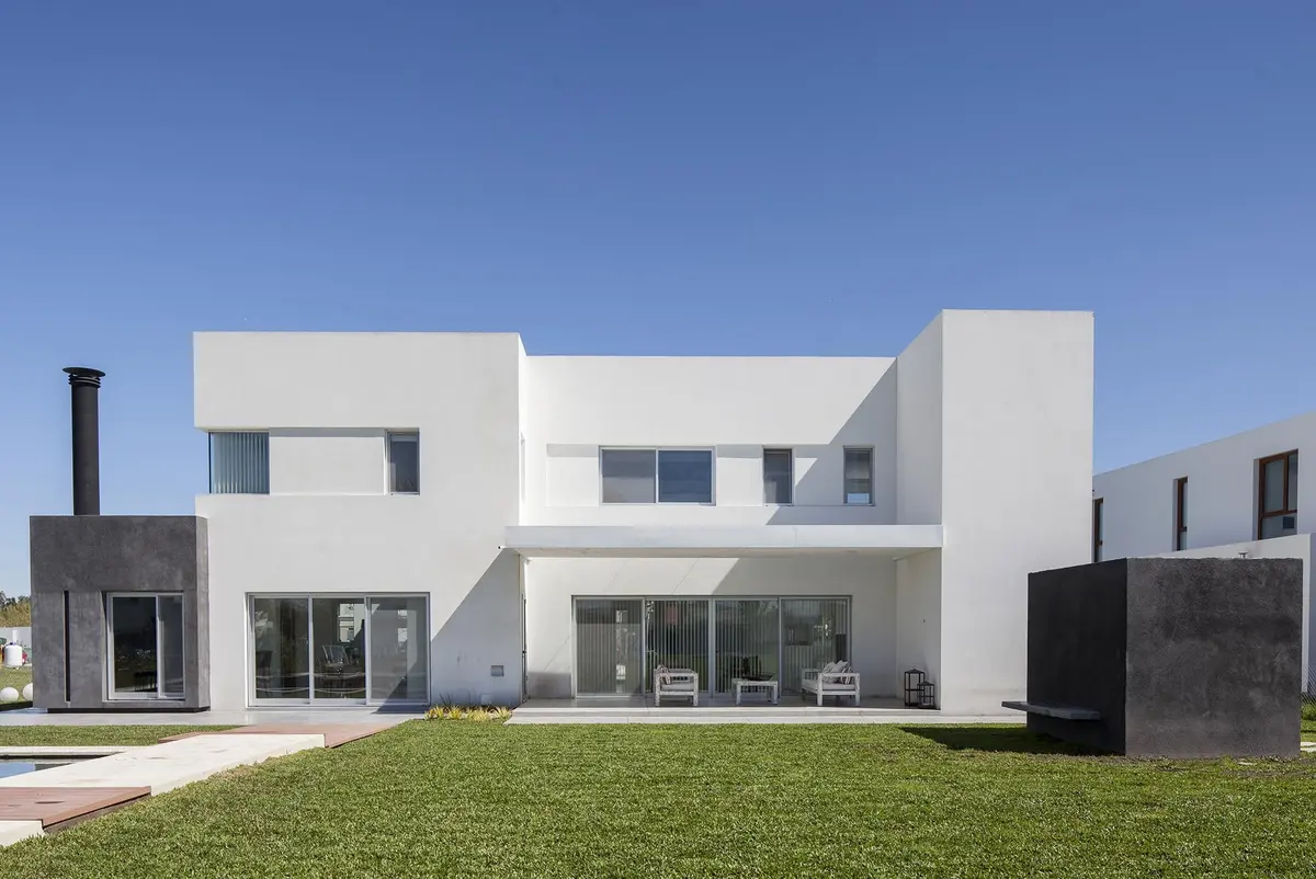 fachada moderna con ventanas amplias y detalles en metal negro — proyecto Casa FA, por Estudio GR, en City Bell