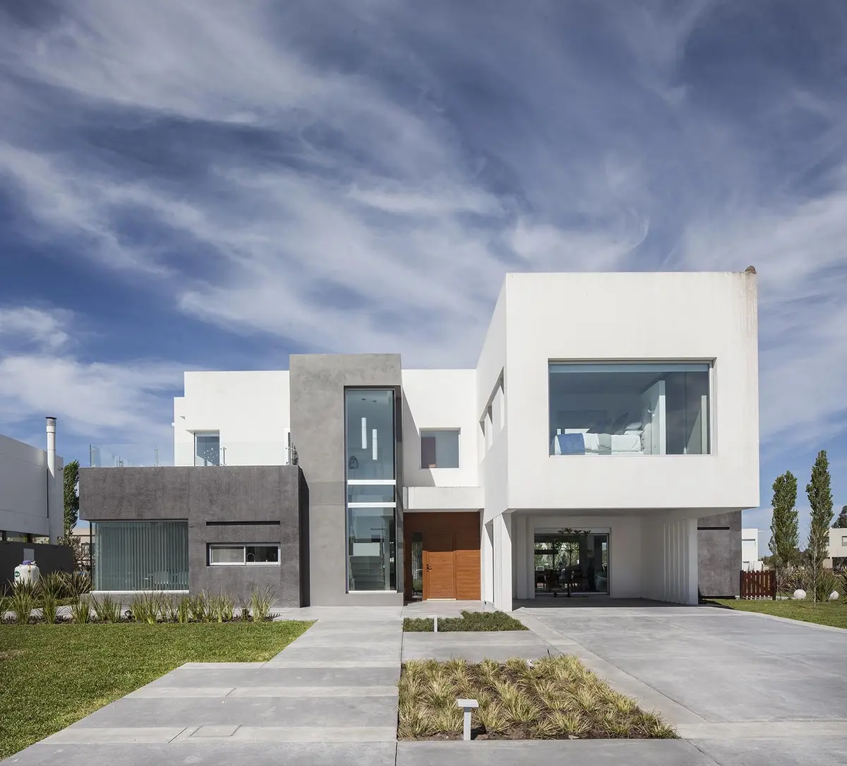 fachada moderna con volúmenes geográficos y texturas contrastantes — proyecto Casa FA, por Estudio GR, en City Bell