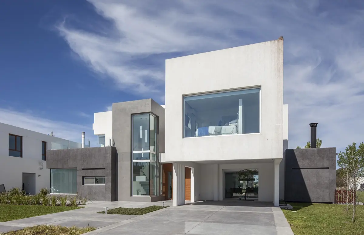 Casa moderna com fachada de concreto branco e cinza — projeto Casa FA, por Estudio GR, em City Bell