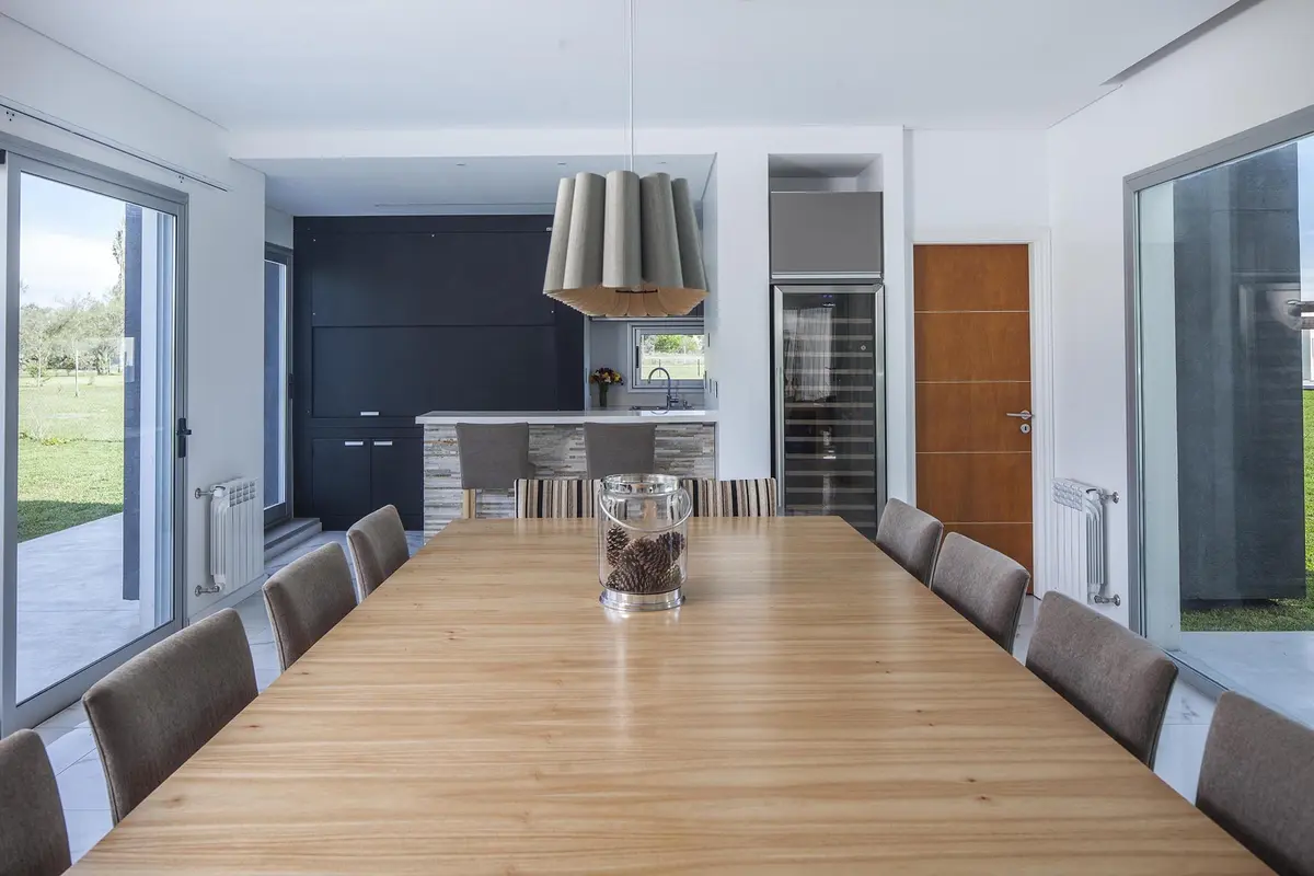 Sala de jantar e cozinha modernas e abertas com muita luz natural — projeto Casa FA, por Estudio GR, em City Bell