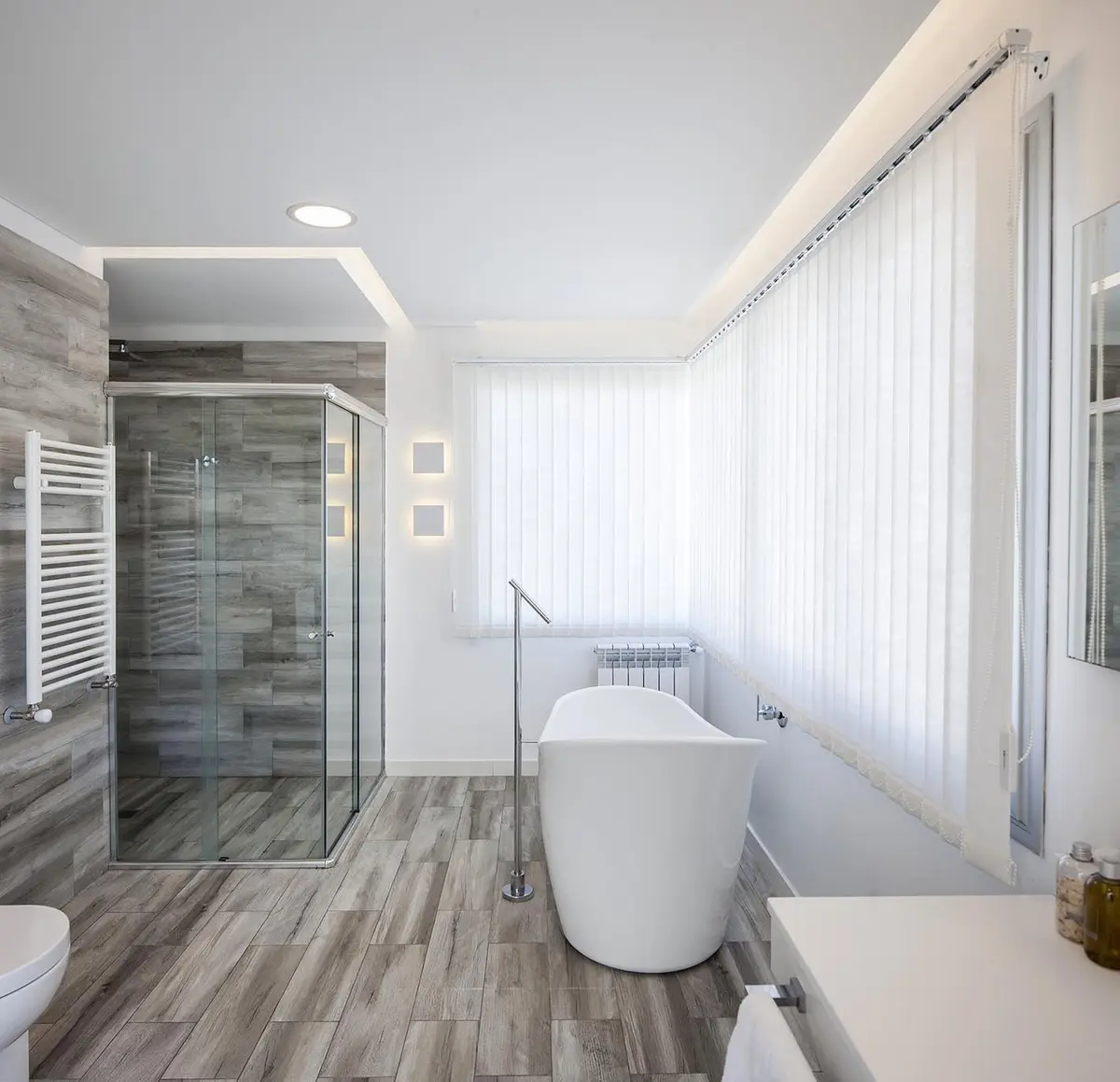 Baño moderno con bañera exenta y cortinas verticales — proyecto Casa FA, por Estudio GR, en City Bell