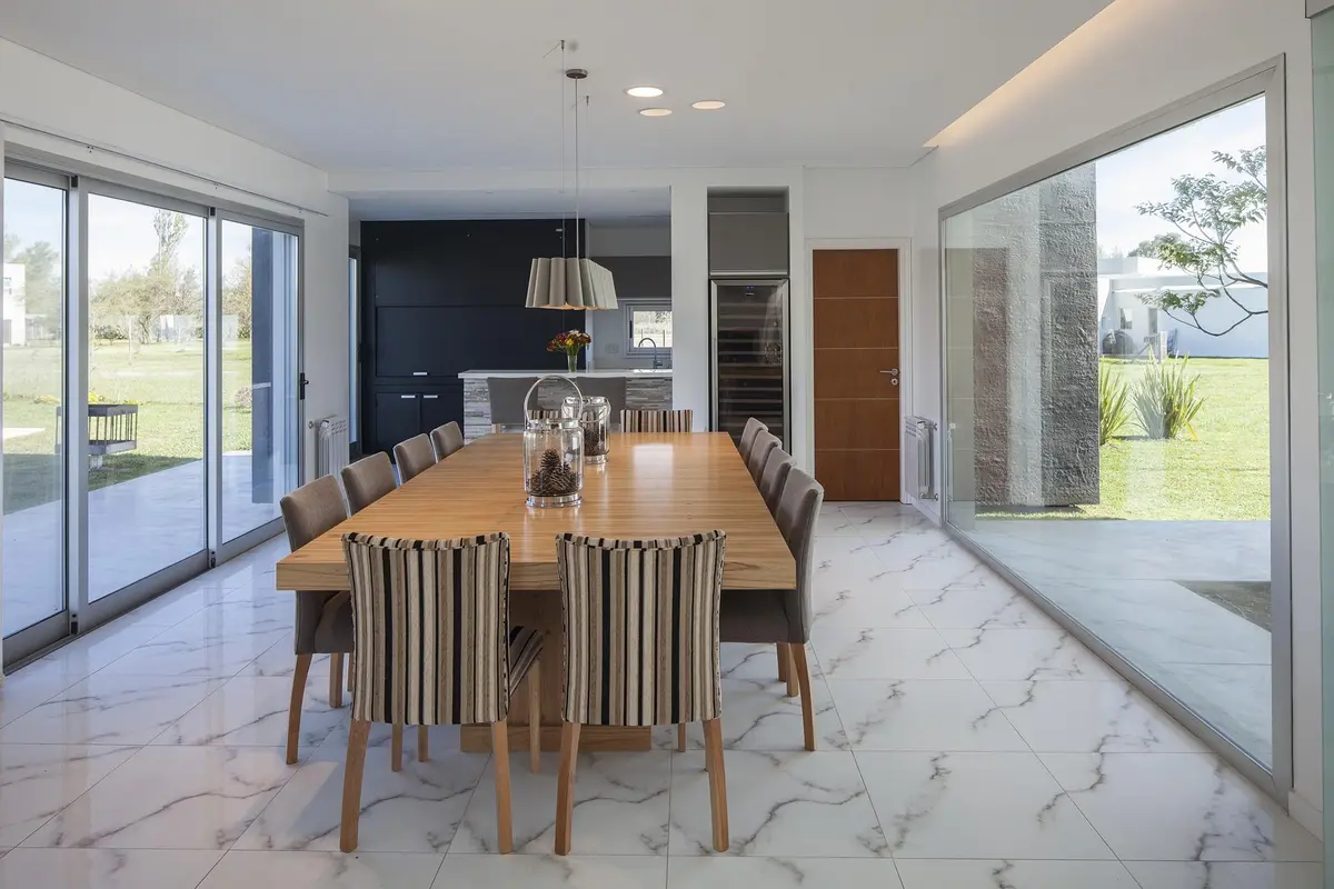 Comedor moderno abierto a living con grandes ventanales — proyecto Casa FA, por Estudio GR, en City Bell